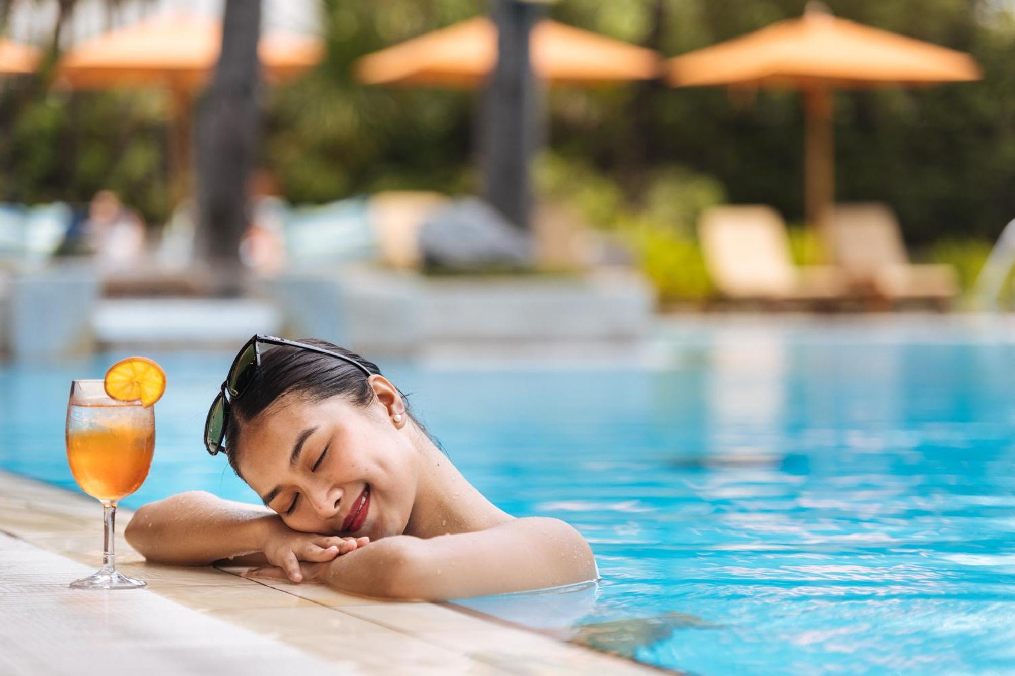 The Peninsula Manila Hotel Makati City Exterior photo A woman relaxing at a pool